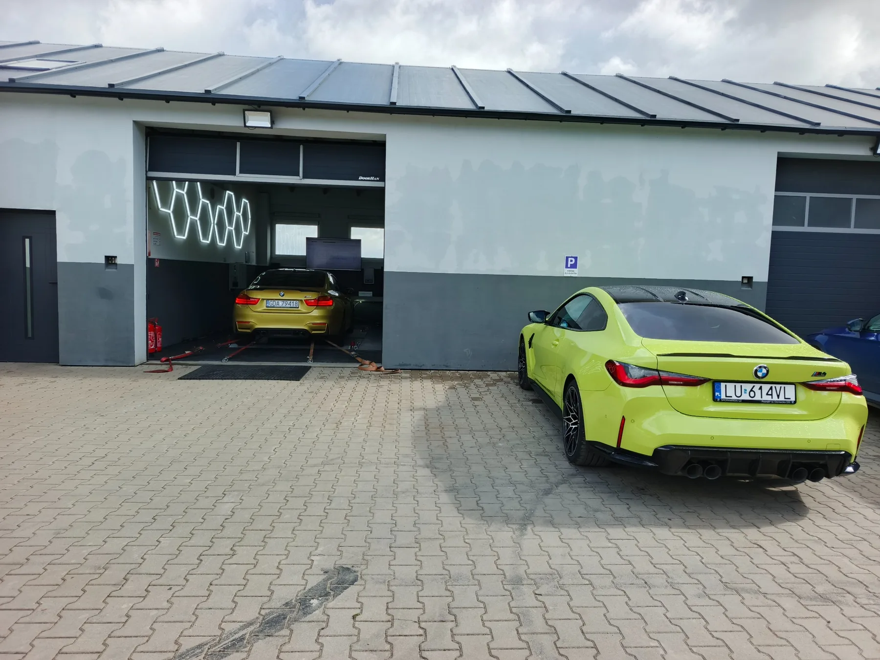 Hamownia MNgarage z otwartą bramą i BMW M4 w środku